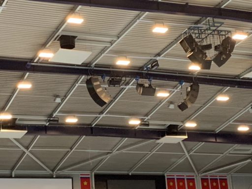 Lichten en geluidsinstallatie aan het plafond van een sporthal.