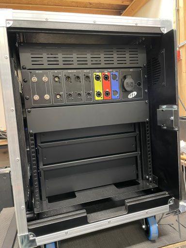 Een open apparatuur rack met verschillende aansluitingen en lades aan de binnenkant.